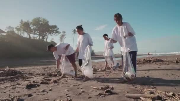 Arc Shot Four Indonesian Ecology Activists Trash Bags Walking Sandy — Stock Video