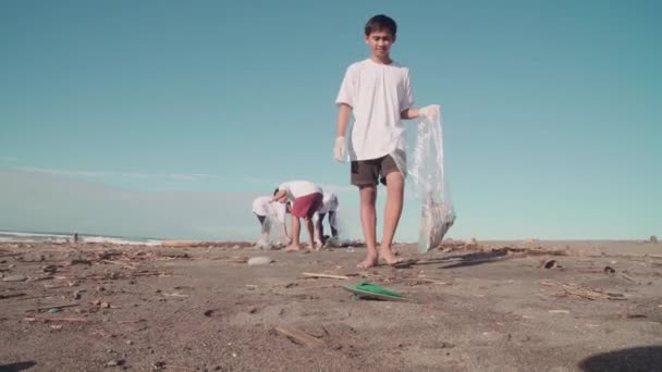 Menino Indonésio Jovem Com Equipe Ambientalistas Limpando Área Praia Lixo — Vídeo de Stock