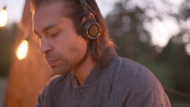 Modern Kafkas Inin Kulaklıklarıyla Sesi Ayarlarken Güvertede Yaylı Işıklarla Süslenirken — Stok video
