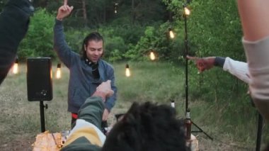 Çok ırklı arkadaşlardan oluşan neşeli bir grup yazın açık hava partisinde DJ müziği eşliğinde dans ederek iyi vakit geçiriyorlar.