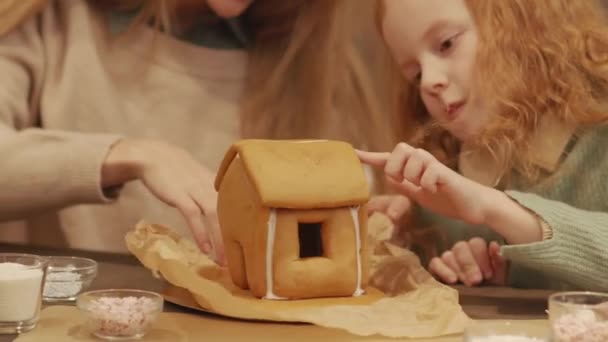 Closeup Little Red Haired Girl Looking Handmade Gingerbread House Gluing — Stock Video