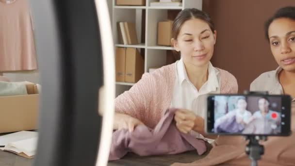 Çok Irklı Genç Kadınların Masada Oturup Kıyafetlerini Kameraya Gösterirken Birlikte — Stok video