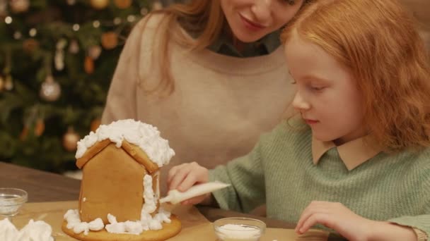 테이블에 머리의 소녀의 크리스마스 진저브레드 저녁에는 크림으로 장식되어 — 비디오