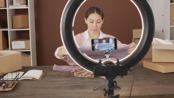Sporing Asiatiske Kvindelige Video Blogger Smilende Viser Tøj Til Mobiltelefon – Stock-video