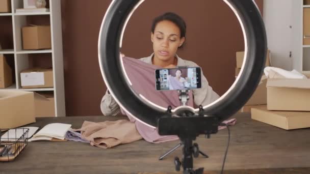 Rastreamento Tiro Preto Fêmea Vídeo Blogger Sentado Mesa Mostrando Roupas — Vídeo de Stock
