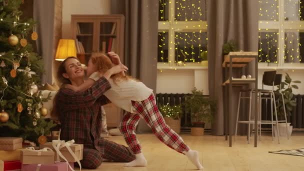 Kırmızı Kıvırcık Saçlı Süslenmiş Noel Ağacının Altında Annesine Koşan Hediyeleri — Stok video