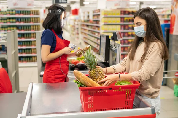 超市收银员和顾客在验尸检疫日遵守个人保护规定 戴口罩 — 图库照片