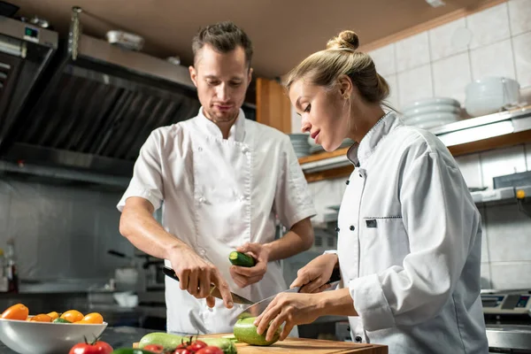 Joven Chef Profesional Seguro Mismo Con Cuchillo Pepino Consultando Aprendiz —  Fotos de Stock