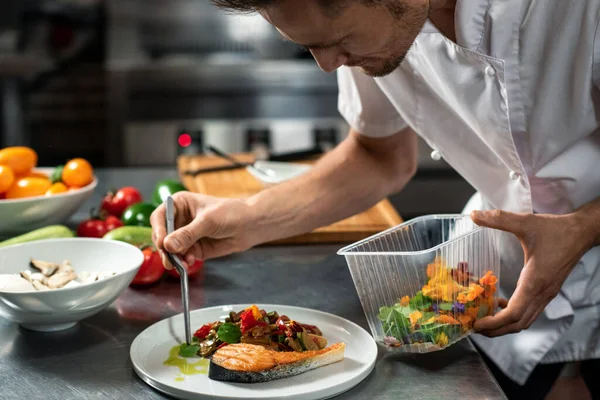 Joven Chef Macho Inclinándose Sobre Verduras Asadas Trozo Salmón Frito —  Fotos de Stock