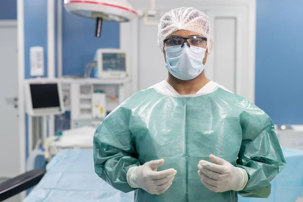 Udany Chirurg Męski Mundurze Ochronnym Masce Rękawiczkach Okularach Patrzący Ciebie — Zdjęcie stockowe