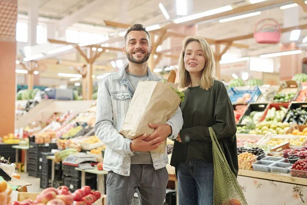 站在农贸市场上共同购买有机食品的年轻夫妇的画像 — 图库照片