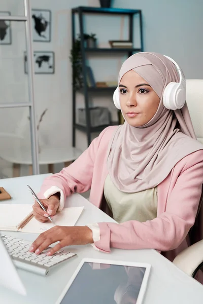 Joven Mujer Musulmana Seria Auriculares Hijab Ropa Casualwear Inteligente Sentado —  Fotos de Stock