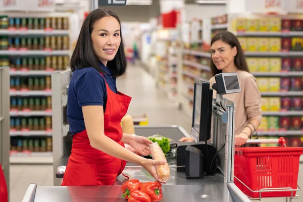 有吸引力的亚洲出纳员身穿红色围裙 在收银台为顾客服务的垂直肖像 — 图库照片