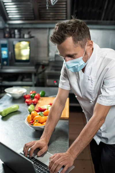 Jeune Chef Professionnel Uniforme Masque Protection Penchant Sur Table Cuisine — Photo