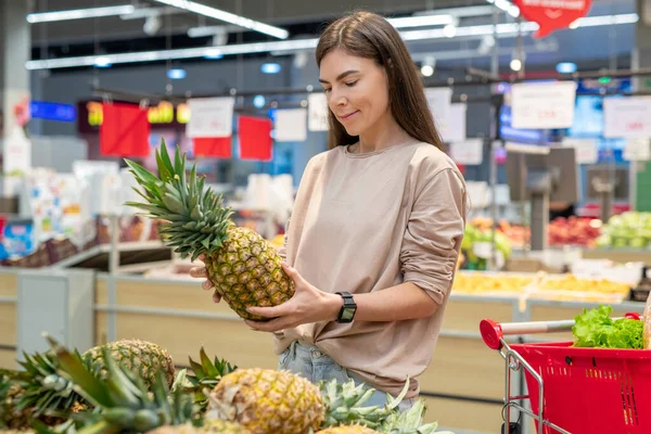 在现代超级市场 穿着休闲装的年轻女性选择最好的菠萝 复制空间 — 图库照片