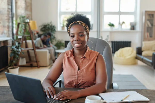 Sorrindo Jovem Africano Freelancer Feminino Olhando Para Você Durante Trabalho — Fotografia de Stock