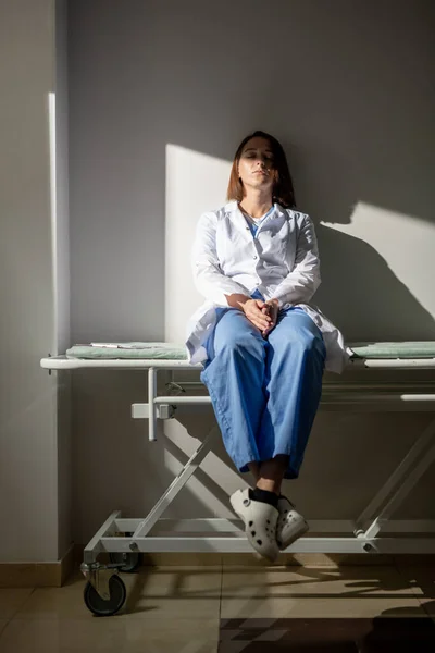 Young Exhausted Nurse Covid Hospital Whitecoat Uniform Sitting Medical Cart — Stock Photo, Image