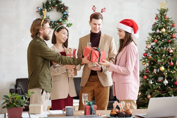 Young Bearded Businessman Giving Packed Xmas Gift Female Colleague Santa — Stock Photo, Image