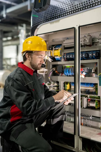 Moderno Giovane Ingegnere Fabbrica Abbigliamento Lavoro Hardhat Scorrimento Touchpad Mentre — Foto Stock