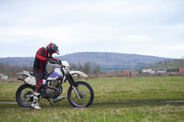 Jeździec Uruchamia Motocykl Wsi Stojąc Przeciwko Środowisku Naturalnemu — Zdjęcie stockowe