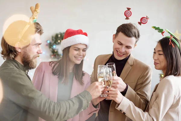 Jóvenes Colegas Alegres Diademas Navidad Tintineo Con Flautas Champán Mientras —  Fotos de Stock