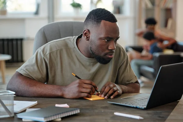 Young African Man Pencil Notepaper Sitting Table Front Laptop Looking — Stock Photo, Image
