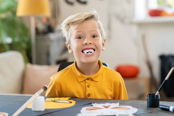 Retrato Garoto Engraçado Com Presas Como Vampiro Sentado Mesa Fazendo — Fotografia de Stock