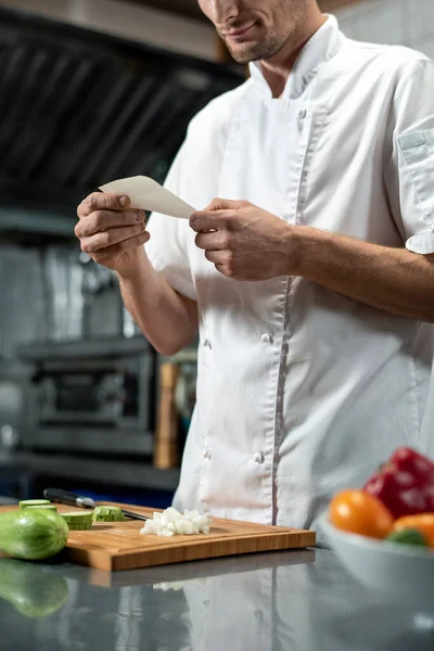 Joven Chef Uniforme Mirando Través Lista Ingredientes Para Ensalada Verduras — Foto de Stock