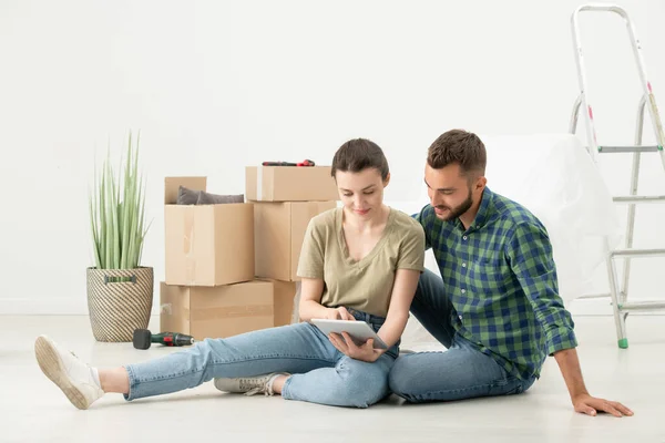 Positive Young Couple Sitting Floor New Apartment Moving Stuff Using — Stock Photo, Image