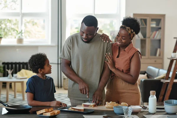 Giovane Uomo Africano Preparare Panini Prima Colazione Mentre Piedi Tavolo — Foto Stock