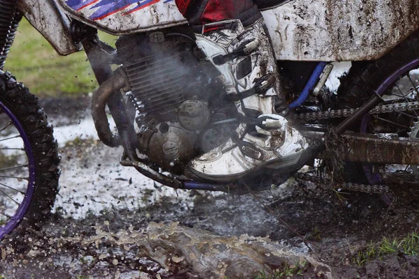 ペダル上のプロのバイカーの足で泥の中に散在するオートバイ — ストック写真
