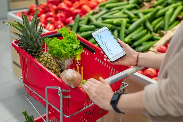 Onherkenbaar Persoon Met Winkelwagentje Supermarkt Zoek Naar Boodschappenlijstje Smartphone — Stockfoto
