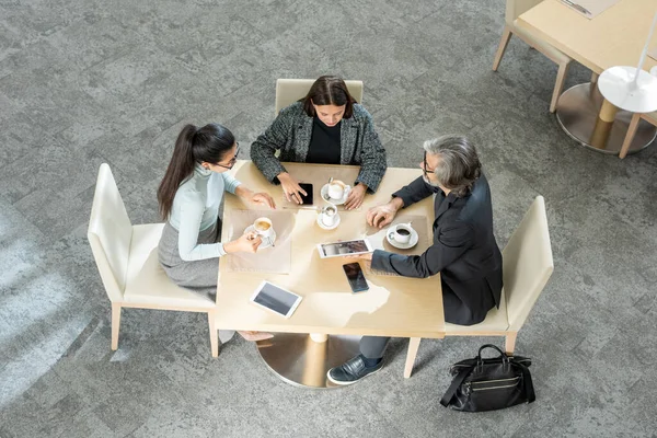 Tres Corredores Interculturales Modernos Ropa Casualwear Inteligente Sentado Mesa Restaurante —  Fotos de Stock