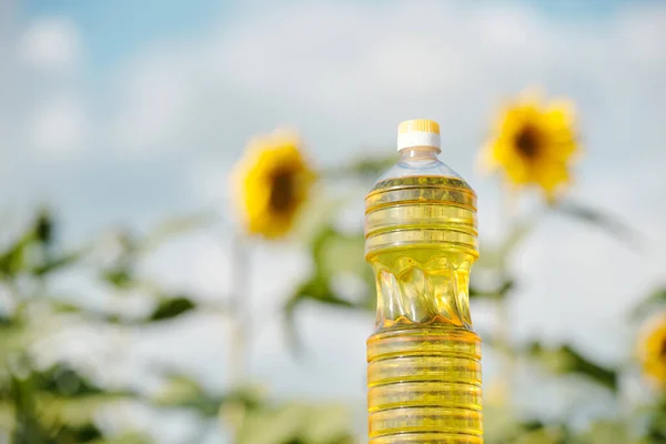 Plastflaska Med Färsk Solrosolja Mot Fält Med Gröna Växter Med — Stockfoto