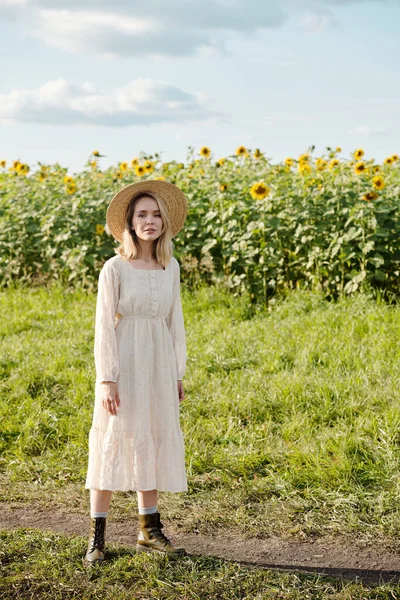 Счастливая Молодая Блондинка Шляпе Белом Романтическом Платье Стоящая Зеленой Траве — стоковое фото