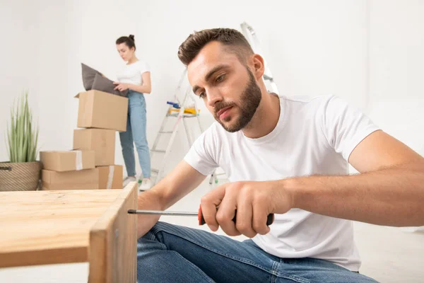 Hombre Barbudo Joven Concentrado Ensamblando Muebles Usando Destornillador Inalámbrico Apartamento —  Fotos de Stock