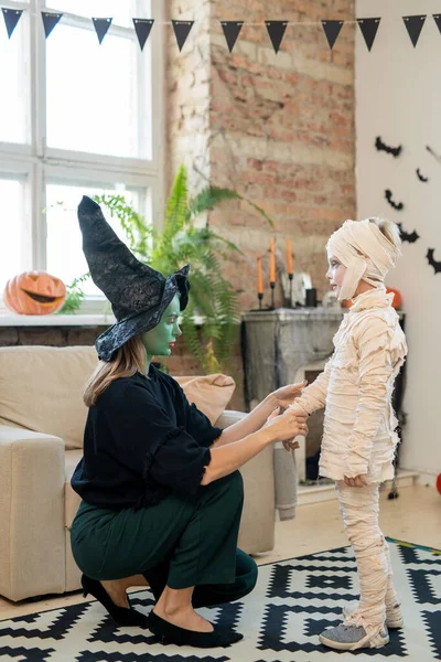 Young Woman Witches Costume Crouching Armchair Adjusting Bandages Boys Costume — Stock Photo, Image