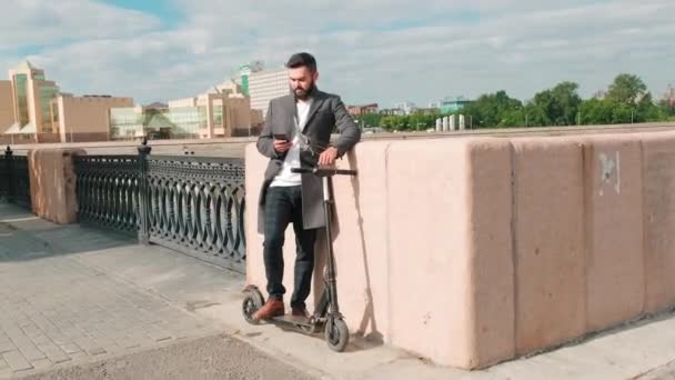 남자가 스쿠터와 통화를 아름다운 풍경을 배경으로 — 비디오