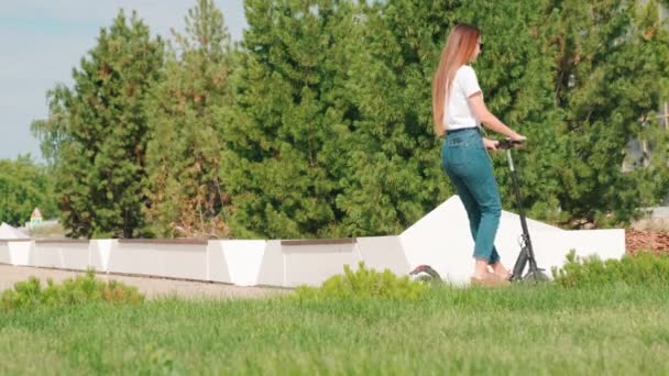 스쿠터를 여성이 여름날에는 공원에 주차하고 의자에 전화를 모습이 선명하게 포착되었다 — 비디오