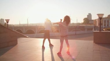 Sağlıklı, enerjik, çok ırklı bir çiftin şehir setinde egzersiz yapıp birbirlerinin önünde esneme egzersizleri yapmaları.