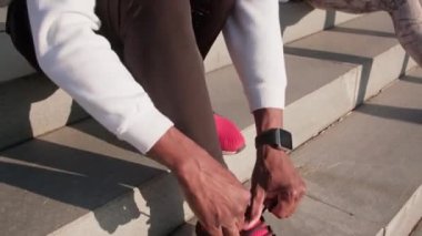 Çok ırklı iki arkadaşın spor yaparken, spor yaparken, ayakkabı bağcıklarını bağlarken ve kadın konuşurken çekilen görüntüler.