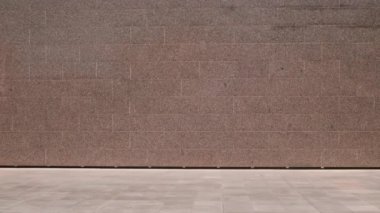 Beyaz kadın sporcunun gündüz vakti beton duvar boyunca koşarken tam bir bıçak darbesi.