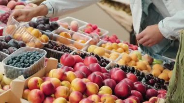 Süpermarketten taze meyve ve böğürtlen seçen tanınmayan insanların el bilgisayarı.