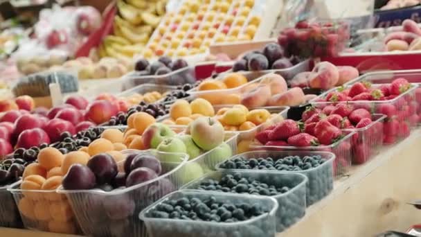 スーパーマーケットや市場で棚のプラスチック食品容器に熟した果物や果実の様々なショットを追跡 — ストック動画