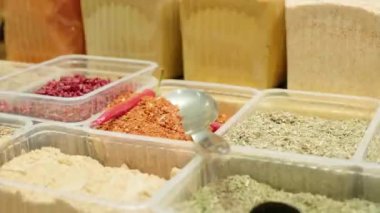 Marketteki plastik yiyecek konteynırlarında bulunan çeşitli baharatların el yapımı.