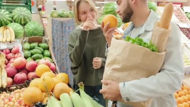 手握幸福伴侣的照片 他们站在市场上吃着鲜活的产品 闻着水果的味道 — 图库视频影像