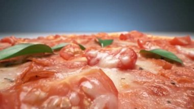 Koyu arkaplanda taze domatesli ve peynirli lezzetli pizzanın macro görüntüsü.