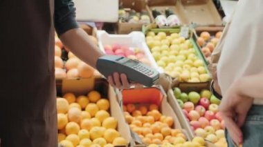 Markette alışveriş yapmak için bankamatik kartını kullanan tanınmayan genç bir kadının el bilgisayarı.