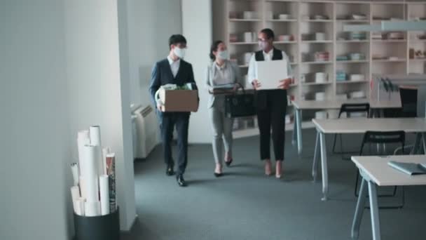 三个戴防护面具的无法辨认的同事带着他们的财物在回家工作后进入办公室 — 图库视频影像