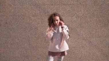 Genç bayan koşucunun kulaklık takıp, bilekliği akıllı telefonla kontrol edip, sabahları dışarıda çalışmaya başlamasını.